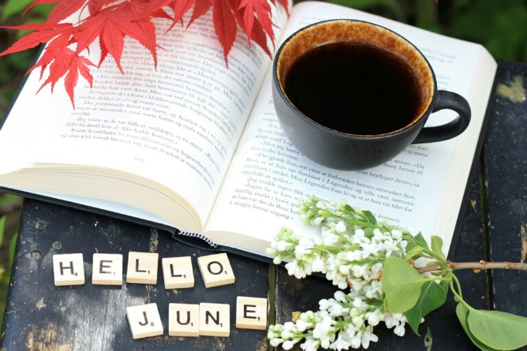 photo of coffee cup on book, wood tiles spell out Hello June